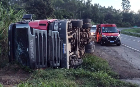 Carreta que transportava cimento tomba ao realizar curva na MG-050, deixando condutor ferido